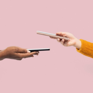 two people holding phones with one taking a picture of the other phone