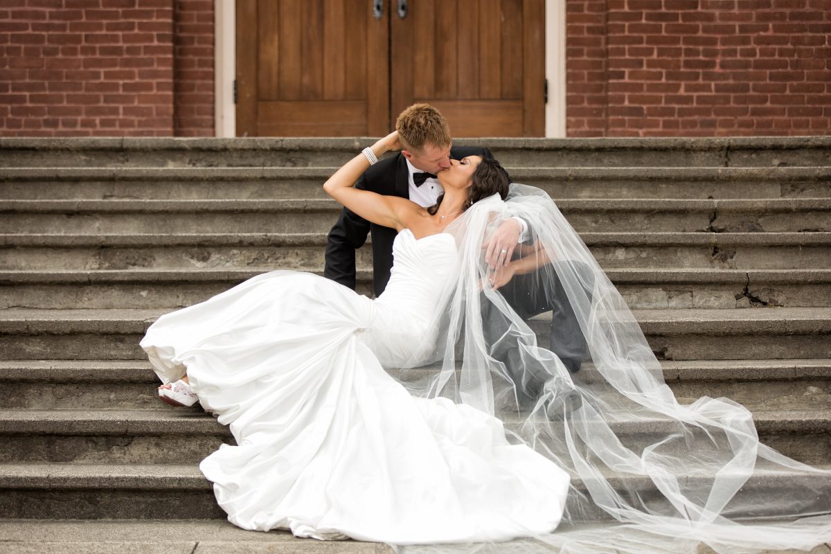 bride and grooming kissing on steps