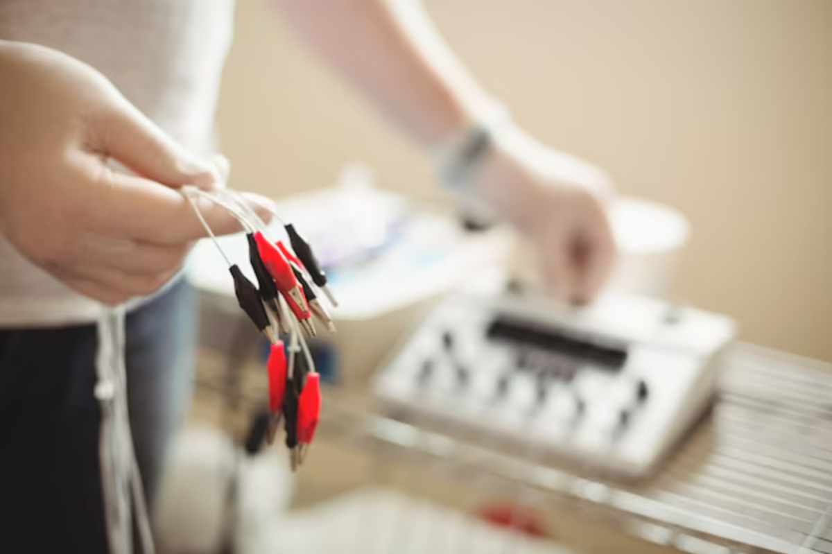 physiotherapist holding electro dry needling cables