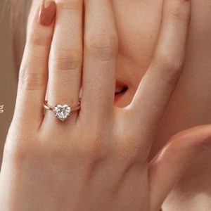 woman wearing heart shaped diamond engagement ring