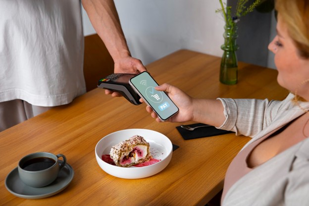 lady pays with phone at restaurant