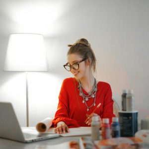 woman in red looking at laptop