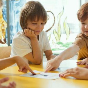 children pointing their fingers to a placecard on a table