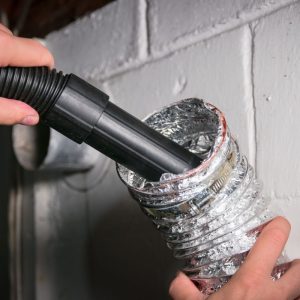 someone cleaning out a dryer vent