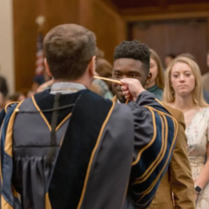 MC President Blake Thompson presents medals to senior Honors College students Xavian Branch and Kayleigh Canoy during the 2025 Honors Convocation.