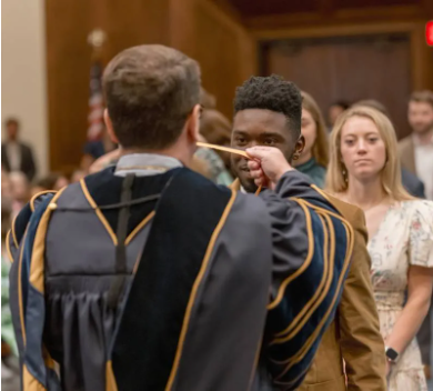 MC President Blake Thompson presents medals to senior Honors College students Xavian Branch and Kayleigh Canoy during the 2025 Honors Convocation.
