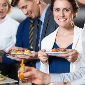 smiling business peopel snacking at a buffet table