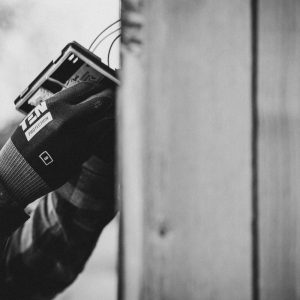 black and white photo of an electrician installing a network box