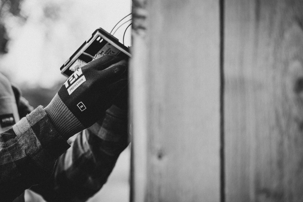 black and white photo of an electrician installing a network box