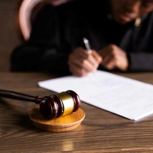 gavel on a table with judge signing paper