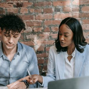 ceo sits with assistant and goes over paperwork