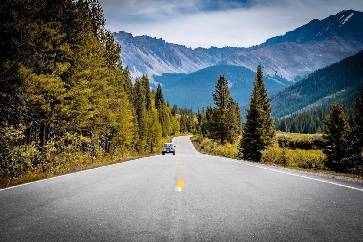 truck driving a highway with mountain scenes