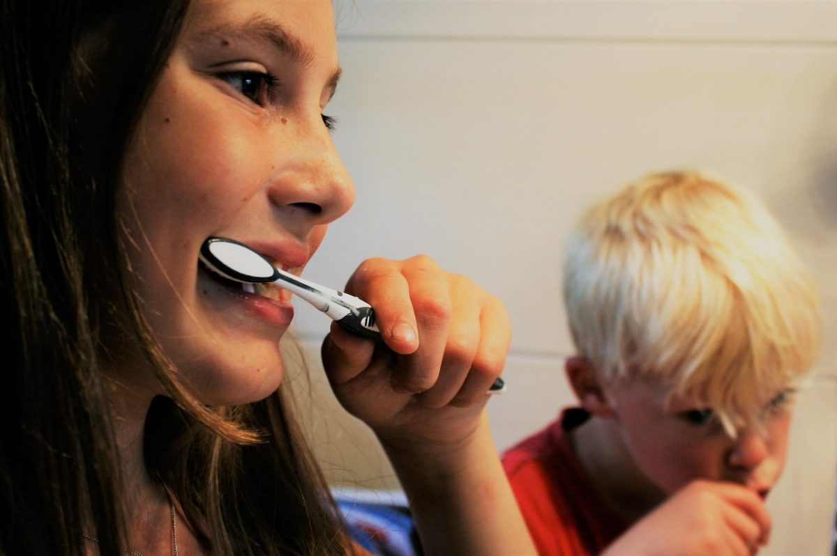 girl and boy brush their teeth