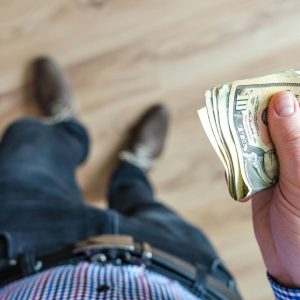 man looking down at money in his hand