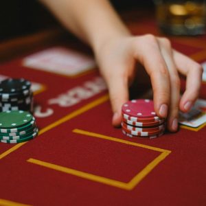 a person holding gaming chips on casino gaming table