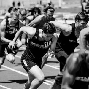 black and white photo of a group of men running on a track