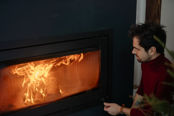 Man Sitting Near a Fireplace