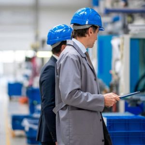men in blue hats and jackets in a factory