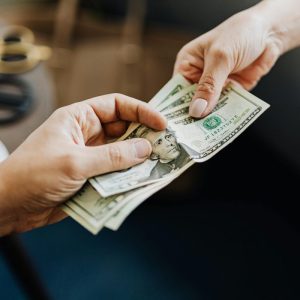hands holding US dollar bills