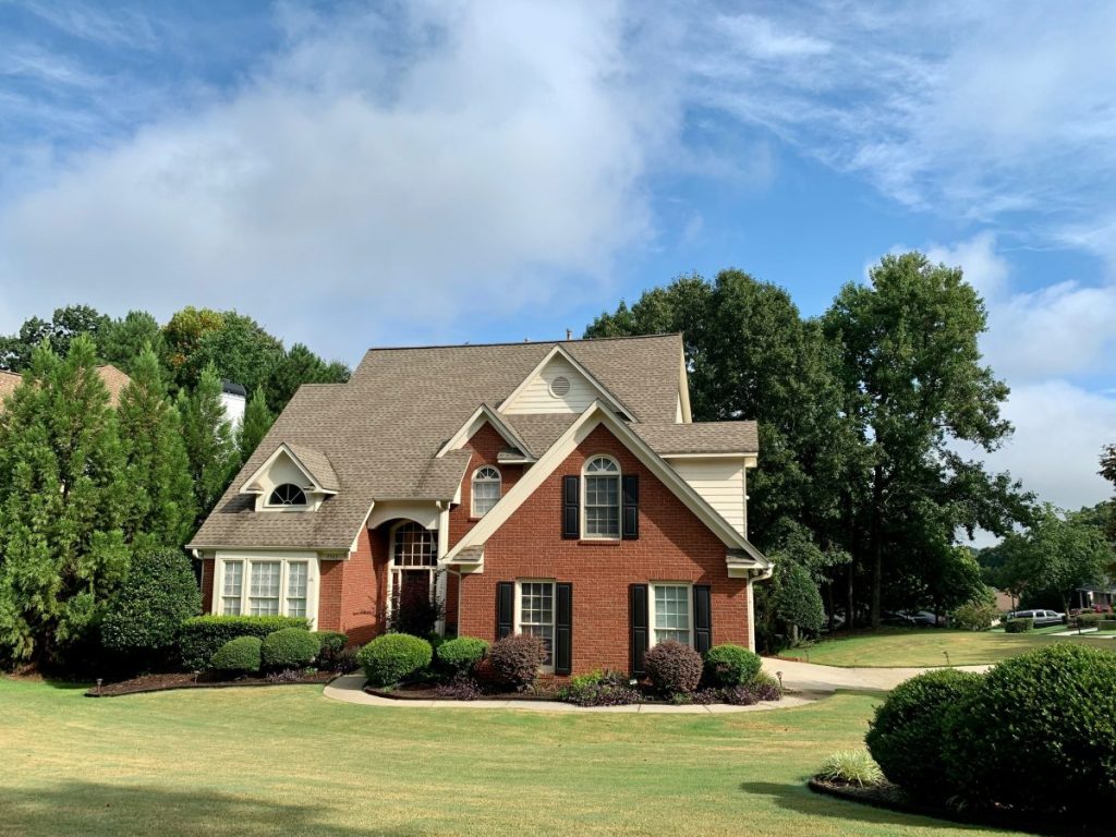 brick home on land surrounded by trees