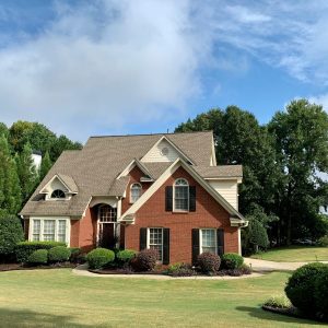 brick home on land surrounded by trees