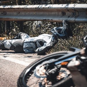 motorcyclist laying on the ground after a wreck