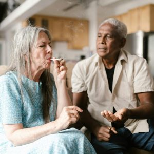 two older people smoking a cigarette