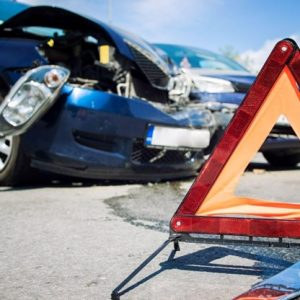 close up of wrecked car with orange triangle