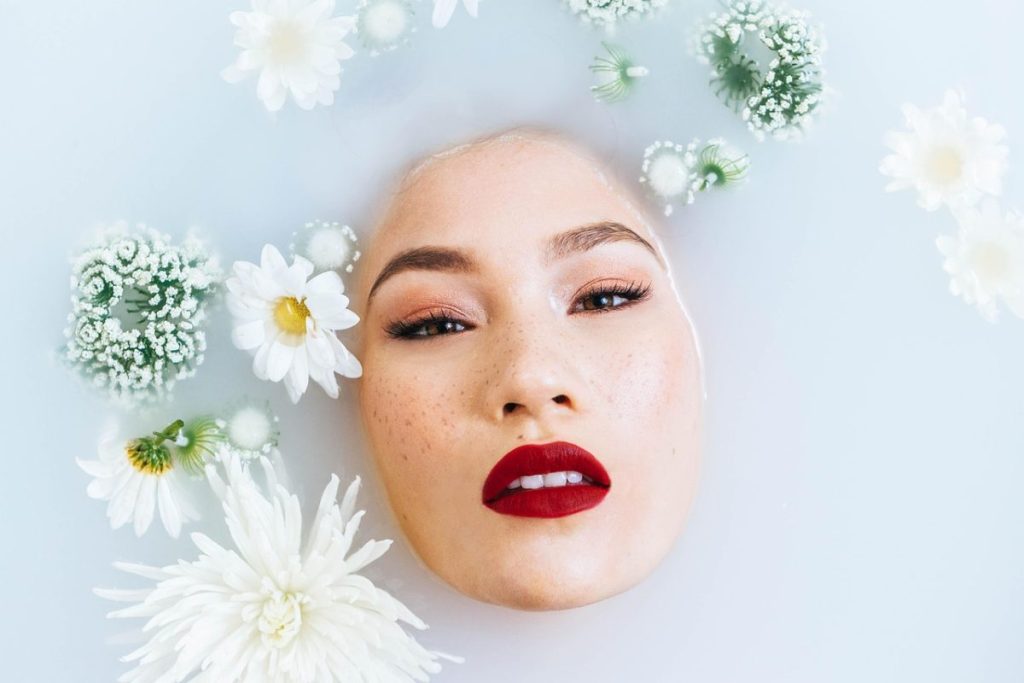 woman in milk bath with flowers