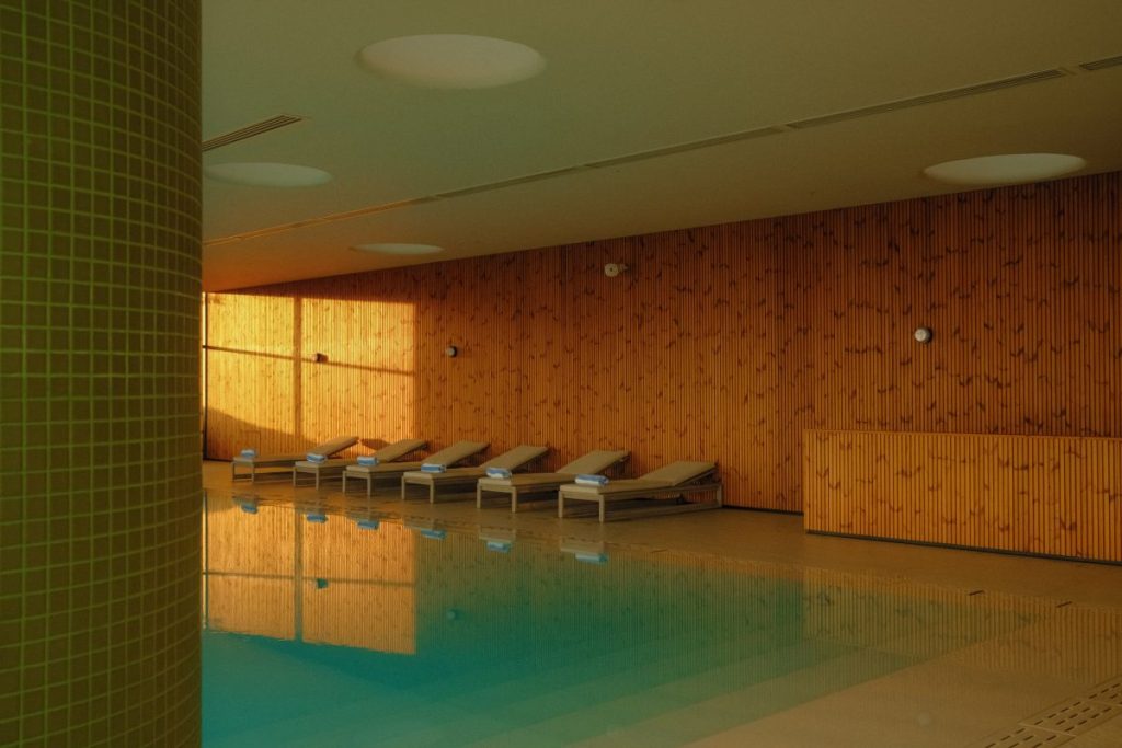indoor swimming pool with chairs lining the walls