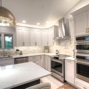 a kitchen with white cabinets and white countertops