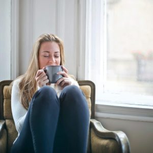 woman sitting in a chair holding a mug