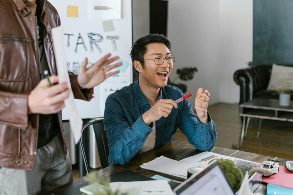 man sitting at a table doing a presentation