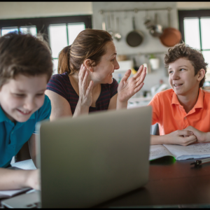 Mom and sons completing homeschool lesson on laptop