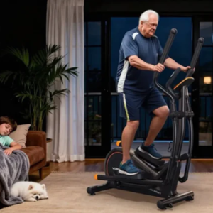 man riding eliptical while boy sleeps on couch
