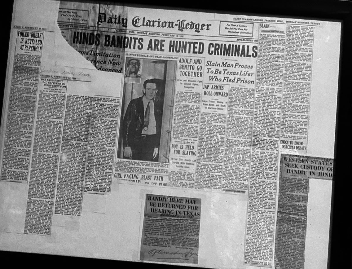Escapees from a Texas prison targeting Ratliff Motor Company as an easy way to obtain traveling funds were stopped by the Ratliff brothers. Traveling through Texas and Louisiana on a five-day crime spree, the two men first stopped in Vicksburg before driving to Clinton, where they made the unfortunate decision to rob the Ratliff garage. Earlier burglary attempts had called for an alarm system to be installed, and the brothers were ready with shotgun and buckshot when the alarm sounded. The early morning attempt resulted in one man being shot and the other captured. The lead story in the February 14, 1938, issue of The Clarion-Ledger shared details, including the statement of the surviving escapee. The clippings from The Clarion-Ledger and the evening edition, The Jackson Daily News, are now preserved in a framed display.