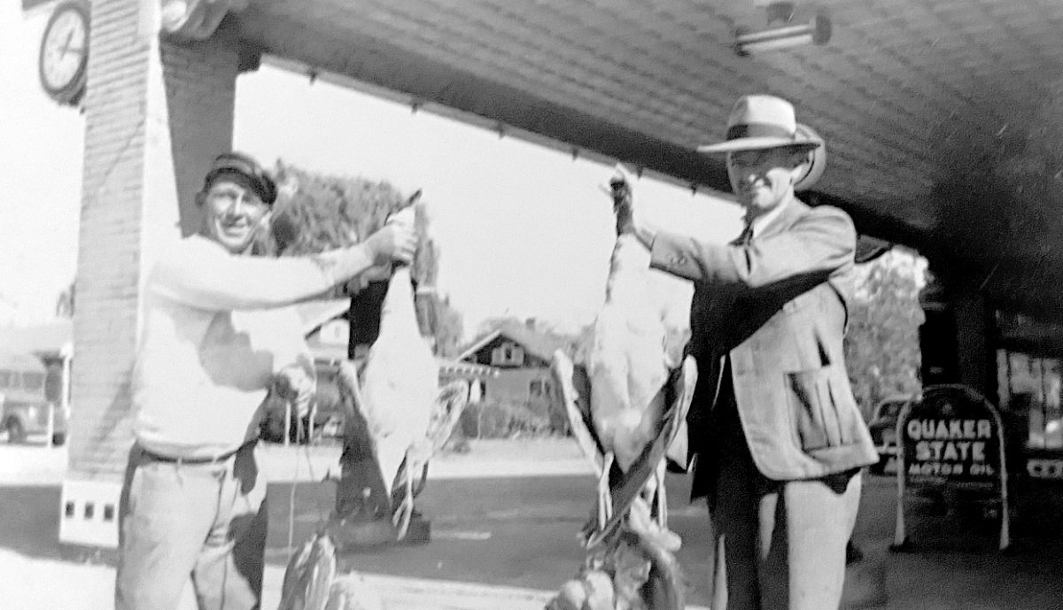 Edward Ratliff Jr. (right) and fellow hunter and fisherman Pettigrew Warren (left) display their catches at Ratliff Motor Company, which opened for business in 1927. The company clock is shown in the upper left corner of the photo. The clock disappeared as time passed but has been located, with plans for its return for the 100th anniversary observation in 2027.