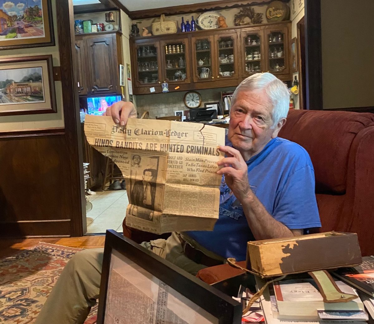 Ed Ratliff shows a newspaper clipping detailing a foiled burglary attempt in 1938 at Ratliff Motor Company.