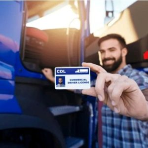 man holding a commercial drivers license in front of truck