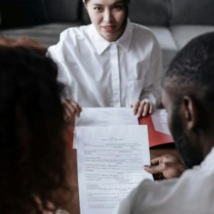 female lawyer meeting with couple talking over paperwork