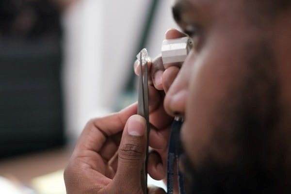jeweler looking at diamond through magnifying glass