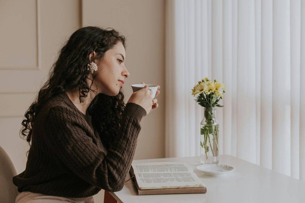 woman enjoying tea while reading a book