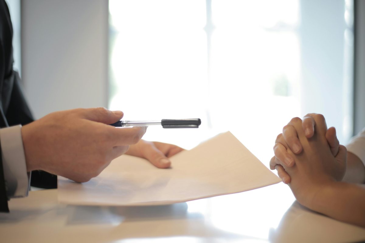 close up of businessman giving contract to woman to sign