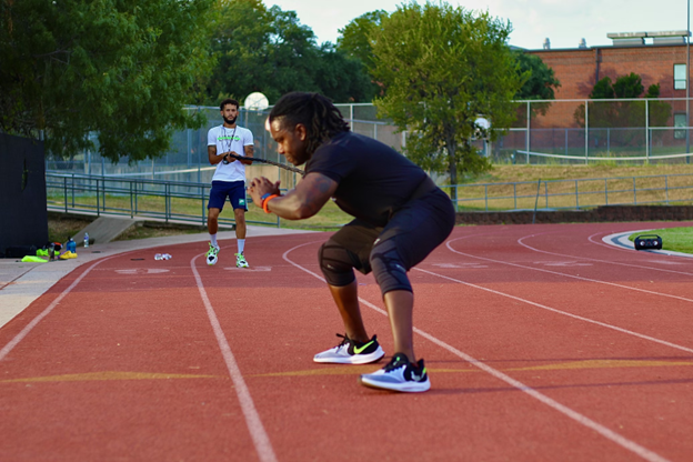 male track athlete stretching on the track before a run