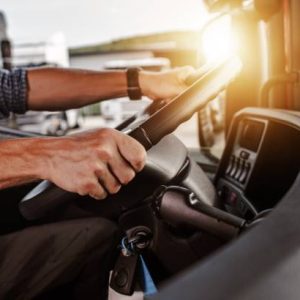 close up of hands on steering wheel in a truck