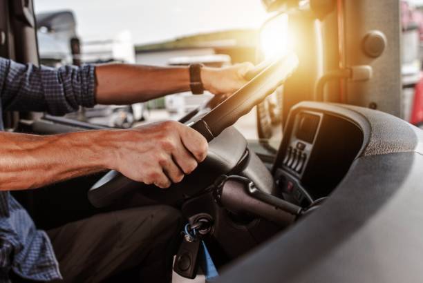 close up of hands on steering wheel in a truck