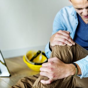 man holding his leg after a fall off a ladder