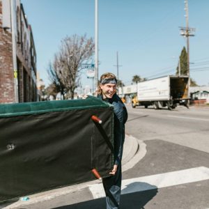 man in black jacket holding a couch