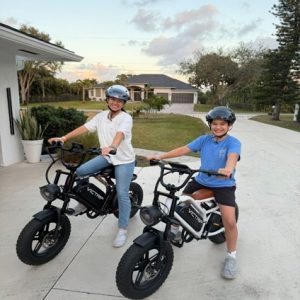 teenagers sitting on electric biks in their driveway