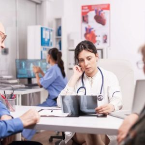 doctor looking at xray of elbow with elderly couple